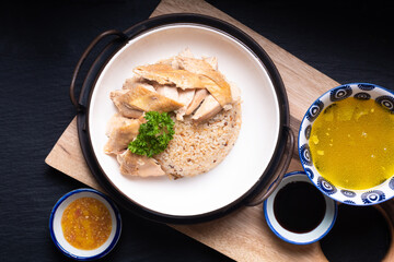 Asian Food concept Hainanese Chicken Rice with sour and sweet soy sauce on wooden board with slate stone background