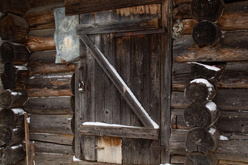 Door of planks in an old wooden building of log cabins in the village