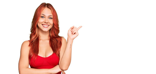 Fototapeta na wymiar Young redhead woman wearing casual clothes with a big smile on face, pointing with hand and finger to the side looking at the camera.