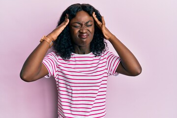 Beautiful african young woman wearing casual striped t shirt with hand on head, headache because stress. suffering migraine.