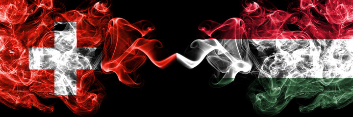 Switzerland, Swiss vs Hungary, Hungarian smoky mystic flags placed side by side. Thick colored silky abstract smoke flags.