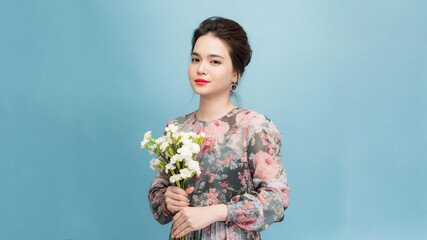 Portrait of satisfied woman with bunch of flowers looking at camera