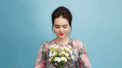 joyful woman with fresh flowers on a light background