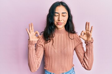 Hispanic teenager girl with dental braces wearing casual clothes relax and smiling with eyes closed doing meditation gesture with fingers. yoga concept.