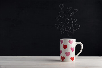 cup on a white wooden surface with painted hearts