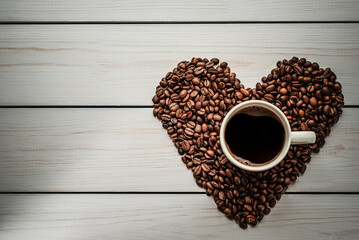 a cup of coffee on the background of a heart made from coffee grains