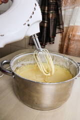 Knead the dough with an electric mixer at home. Baking sweets in the kitchen.