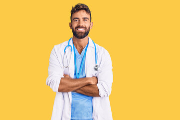 Young hispanic man wearing doctor uniform and stethoscope happy face smiling with crossed arms looking at the camera. positive person.