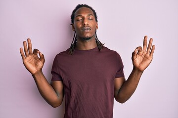 African american man with braids wearing casual clothes relax and smiling with eyes closed doing meditation gesture with fingers. yoga concept.