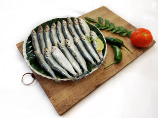 Closeup view of Fresh Indian oil Sardine decorated with herbs and vegetables,Selective focus.White...