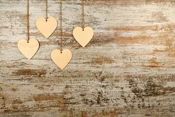 Valentine's Day background. 4 wooden hearts hung with string on a background of pickled old wood. Valentine's day concept. Flat view, top view, copy space
