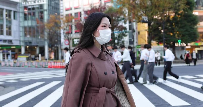 Young Asian woman in Tokyo wearing a mask / 4K slow motion