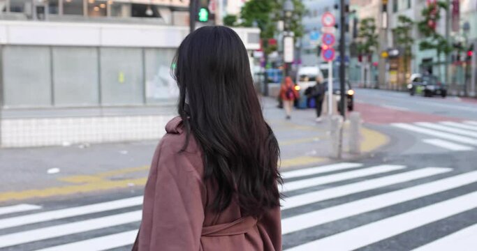 Young Asian woman in city wearing a mask / 4K slow motion