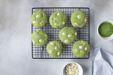 green tea matcha cookies with white chocolate chips on cooling rack. freshly baked pastries. gray background. top view. copy space
