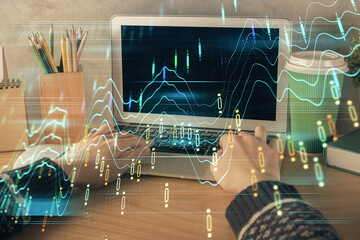 Double exposure of woman hands typing on computer and forex chart hologram drawing. Stock market...
