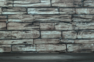 The wall is made of large bricks and wooden boards with a spot of illumination.