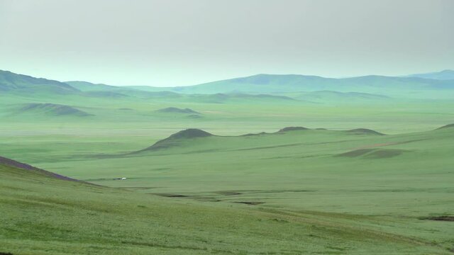 Plain in the treeless wide valley.Grassland prairie meadow wold pasture steppe plateau tableland lowland mountain mountainous terrain geography slope ridge hilly hill hills vast extensive