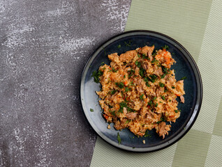 .Pilaf on a round plate on a dark background. Top view, flat lay