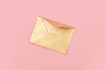 Golden paper envelope isolated on pink background