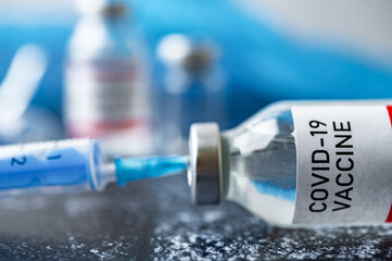 A single bottle vial of Covid-19 vaccine. Medical concept vaccination hypodermic injection...