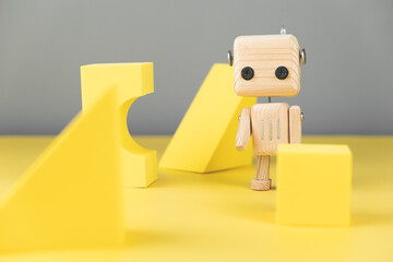 wooden robot toy. environmentally friendly toys for children. on a yellow and gray background, with yellow geometric shapes