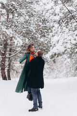 Snowy winter couple walking in the forest