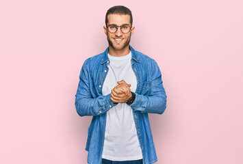 Young caucasian man wearing casual clothes with hands together and crossed fingers smiling relaxed and cheerful. success and optimistic