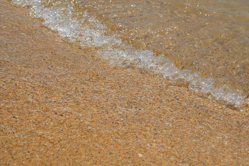 Waves are rolling on a sand sea beach.