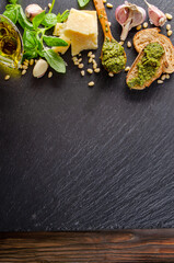 Flat lay view at food ingredients for pesto sauce on slate tray