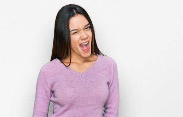 Fototapeta premium Young hispanic girl wearing casual clothes winking looking at the camera with sexy expression, cheerful and happy face.