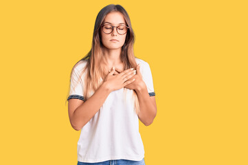 Beautiful caucasian woman wearing casual clothes and glasses looking positive and happy standing and smiling with a confident smile showing teeth