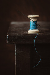 Old spool of thread on wooden table. Selective focus