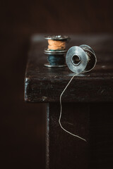 Old spool of thread on wooden table. Selective focus