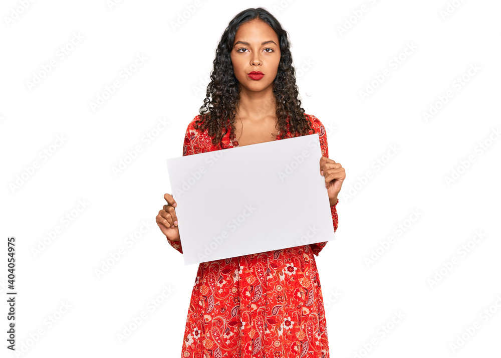 Canvas Prints Young african american girl holding blank empty banner thinking attitude and sober expression looking self confident