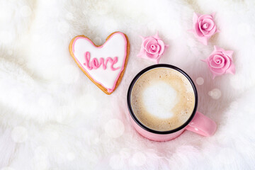 Breakfast in bed on Valentine day with coffee and heart shaped biscuit near flowers