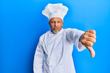 Middle age grey-haired man wearing professional cook uniform and hat looking unhappy and angry showing rejection and negative with thumbs down gesture. bad expression.