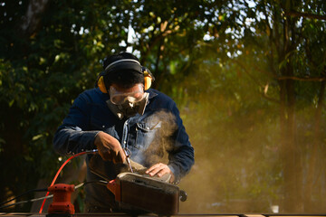 Work carpenter in the carpenter's workshop.The carpenter is removing the wood splinter. To make wood work smoother.