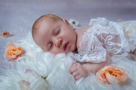 Newborn girl photo on the bed with flowers