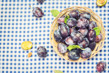 Ripe blue plums in wooden basket