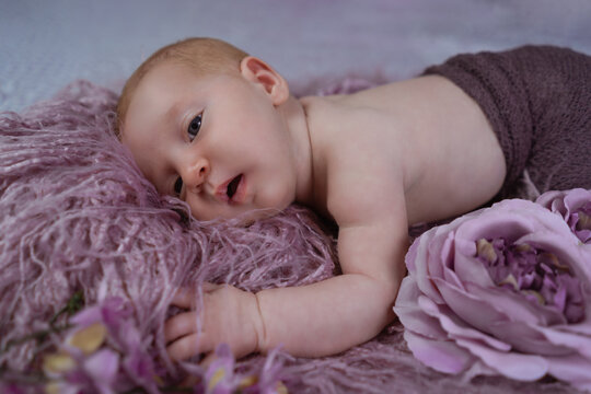 Newborn girl photo on the bed with flowers