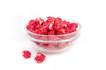 Red caramel popcorn in a glass bowl on a white background