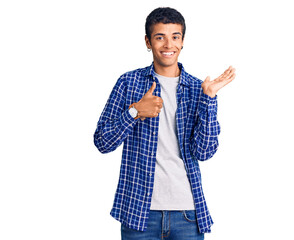 Young african amercian man wearing casual clothes showing palm hand and doing ok gesture with thumbs up, smiling happy and cheerful