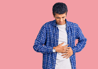 Young african amercian man wearing casual clothes with hand on stomach because indigestion, painful illness feeling unwell. ache concept.