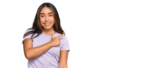 Young latin woman wearing casual clothes cheerful with a smile of face pointing with hand and finger up to the side with happy and natural expression on face