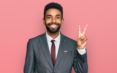 Young african american man wearing business clothes showing and pointing up with fingers number two...