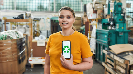 Young girl holding smartphone with recycling sign