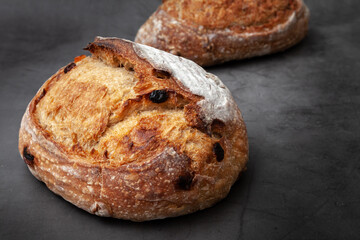 Sourdough bread with mixed fruits and nuts on dark cement background.
