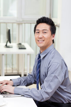 Close-up of a businessman using a laptop in an office