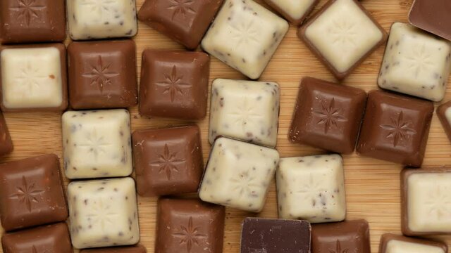Pieces of chocolate, dolly shot. Chocolate cubes, top view.