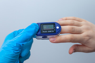 Doctor checks patient oxygen saturation using a portable oximeter